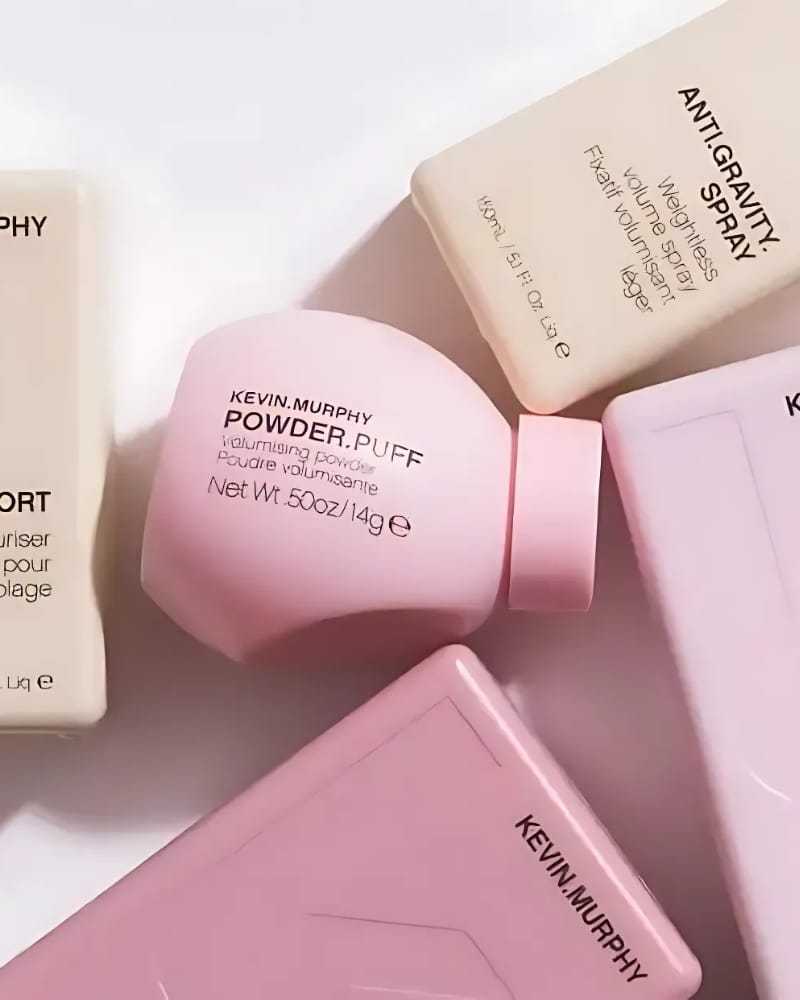 Haircare products arranged on a surface, featuring volumizing powder and a spray bottle.